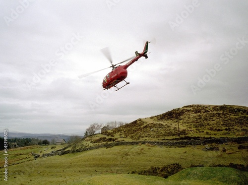 Low angle shot of an Air ambulance helicopter flying over a valley