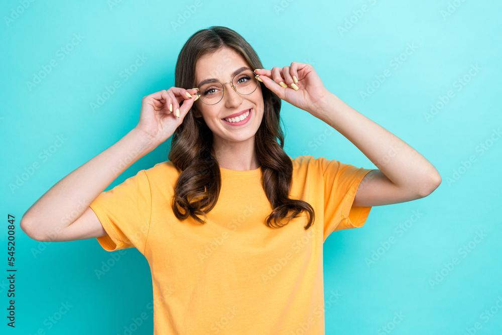 Photo of sweet shiny girl dressed yellow t-shirt arms eyewear smiling empty space isolated teal color background Photo of sweet shiny girl dressed yellow t-shirt arms eyewear smiling empty space isolated teal color background