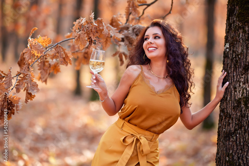 beautiful woman with long hair with a glass of wine in her hand autumn