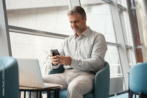 Middle-aged male employee is uses modern devices photo