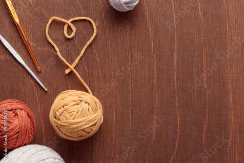 Heart Shaped cotton thread and yarn balls for Crocheting Handmade on a Light Colored Wooden background