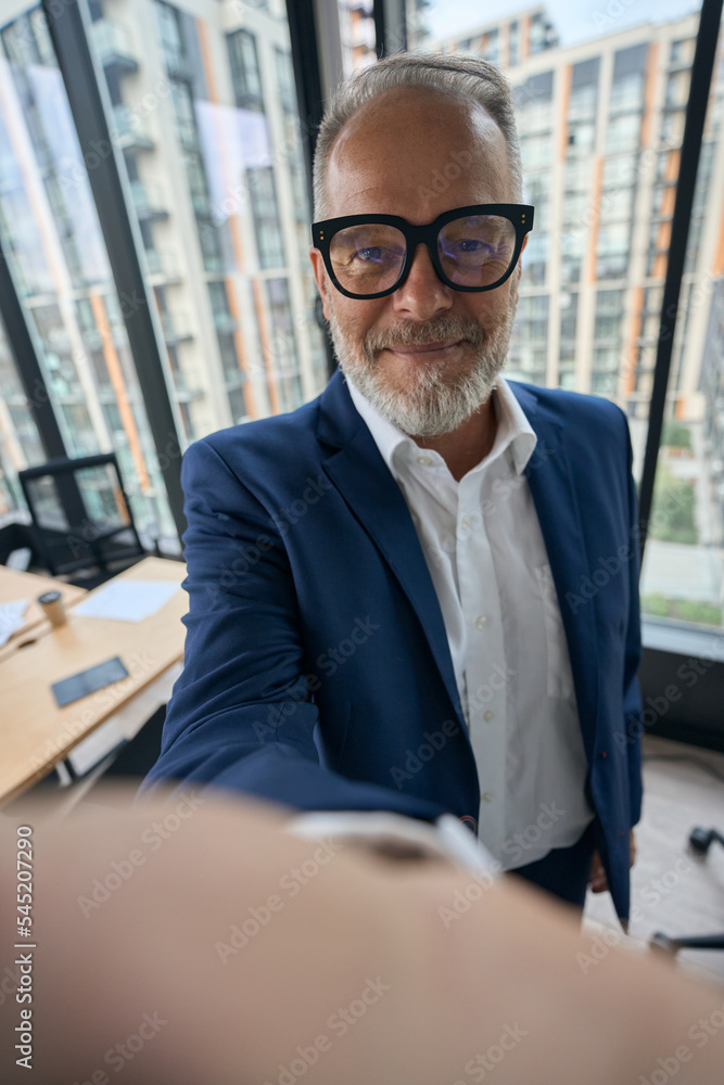 Smiling elegant entrepreneur taking selfie in office Smiling elegant entrepreneur taking selfie in office