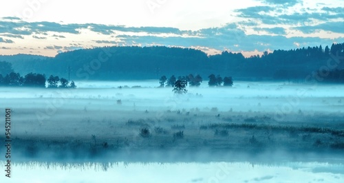 Mesmerizing view of a beautiful blue mist over a tranquil lake at dawn in Russia