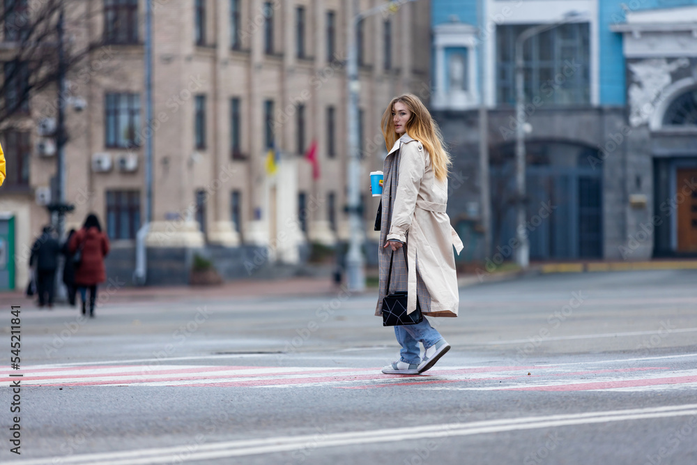 people walk along the street in Kyiv of Ukraine. Woman goes to work in the morning.