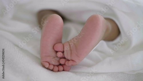 Closeup feet of newborn African black baby isolated on white hospital bed sheet. Healthcare and medical love together lifestyle father or mother’s day background concept.