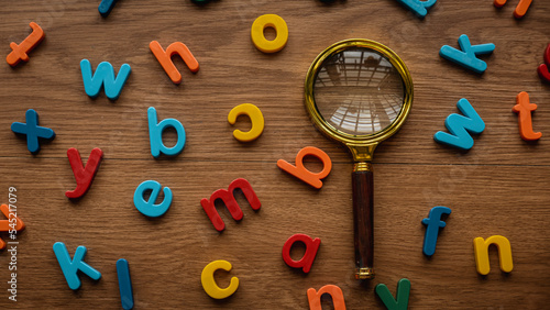 Konstfotografi Scattered colorful alphabet with a magnifying glasses
