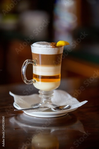 Vertical shot of a tasty glass of barraquito with liquor and milk photo