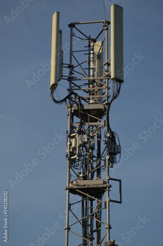 A Telecommunication antenna mast with blue sky background, France