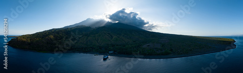 The sun rises behind the beautiful volcano of Sangeang, found just outside of Komodo National Park, Indonesia. The reefs and black sands that surround the island support a wide variety of marine life. photo