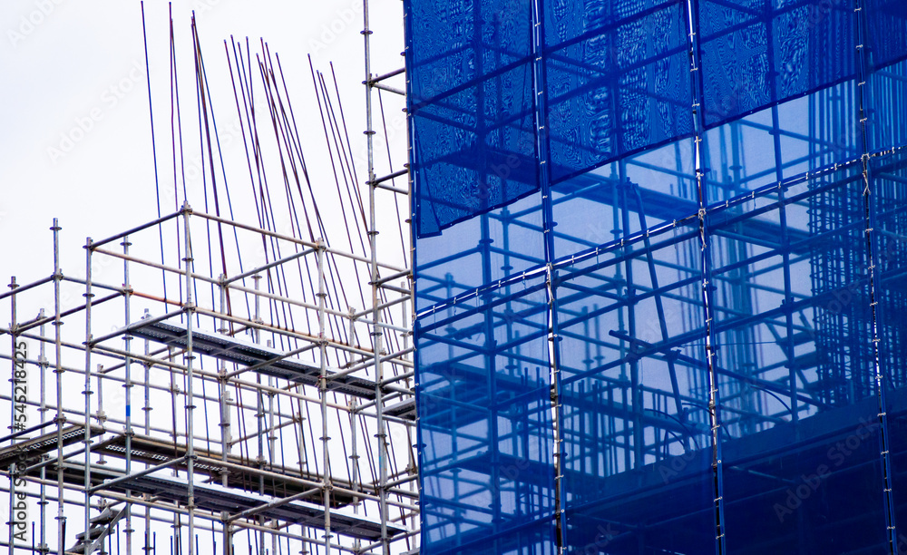 A blue slan surrounds the building under construction. A blue slan surrounds the building under construction.