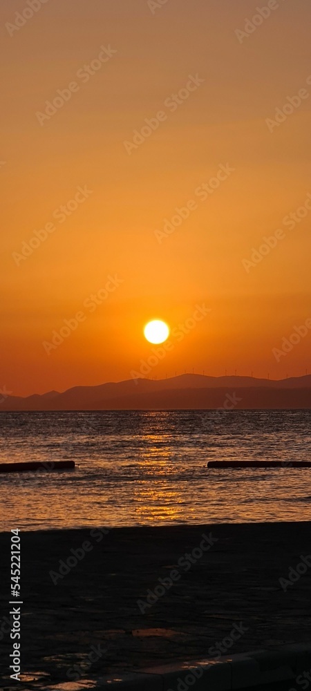 Vertical shot of a bright glowing sunset sky over a seashore