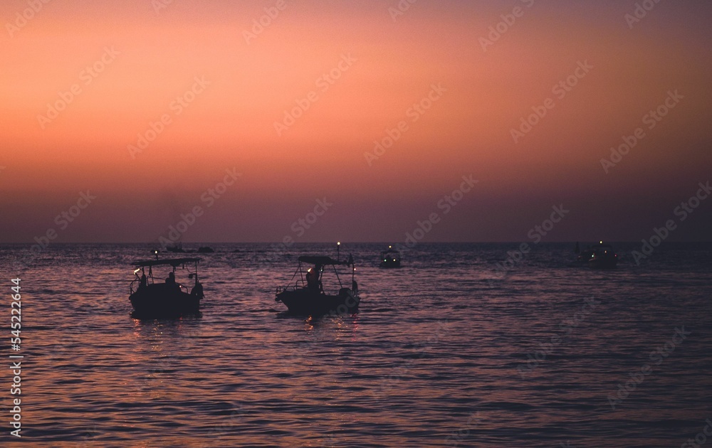 Beautiful shot of silhouettes of boats in the sea during the sunset, Greece