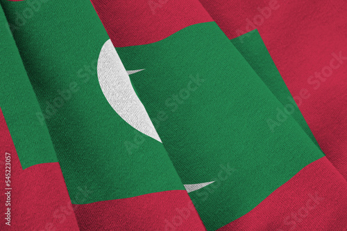 Maldives flag with big folds waving close up under the studio light indoors. The official symbols and colors in banner photo