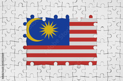 Malaysia flag in frame of white puzzle pieces with missing central part photo