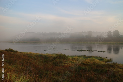 foggy morning over river in summer in countryside