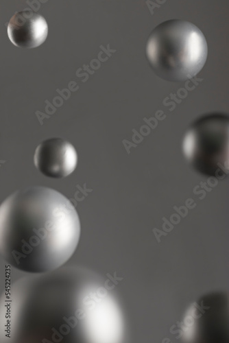 Abstract background with flying silver balls, weightlessness concept. copy space. vertical position.