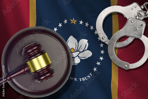 Mississippi new US state flag with judge mallet and handcuffs in dark room. Concept of criminal and punishment photo