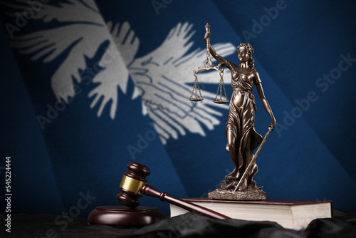 South Carolina US state flag with statue of lady justice, constitution and judge hammer on black drapery. Concept of judgement and guilt photo