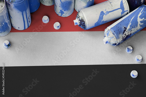 Yemen flag and few used aerosol spray cans for graffiti painting. Street art culture concept photo