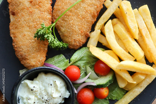 fish and chips. Crumbed hake fillets with chips and salad  photo