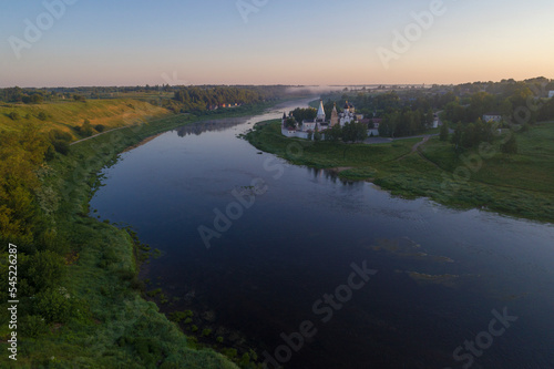 July dawn on the Volga river. View of the Staritstsa Holy Assumption Monastery (aerial photography). Tver region, Russia