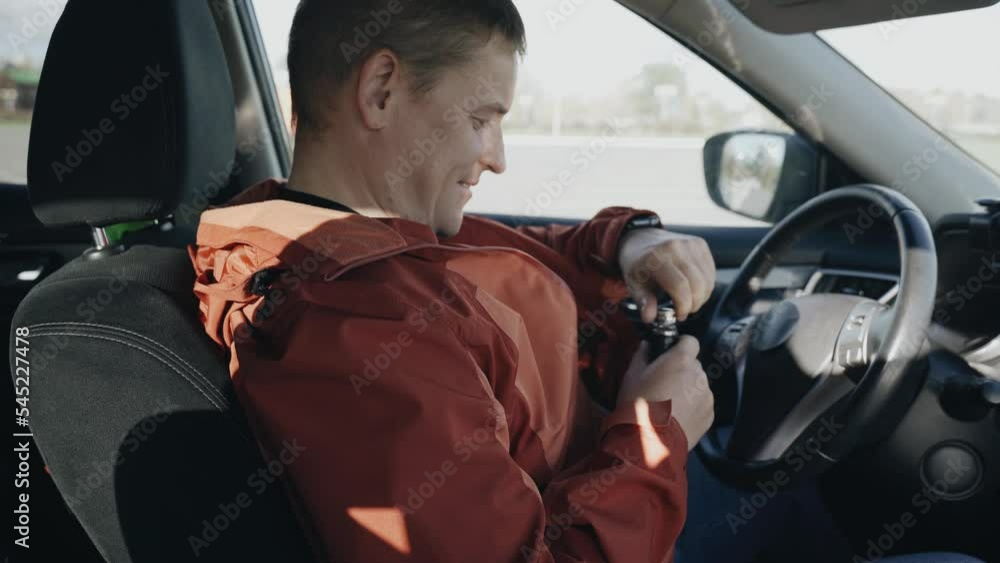 The driver takes out a container of alcohol from the inside pocket of his jacket and drinks it. Road safety. The driver takes out a container of alcohol from the inside pocket of his jacket and drinks it. Road safety.