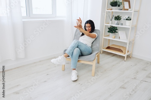 Woman sitting in chair listening to music on wireless headphones at home and dancing, fall lifestyle © SHOTPRIME STUDIO