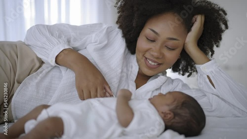 Closeup portrait of beautiful young African American mother day girl kiss healthy newborn baby sleep in bed flat lay copy space. Healthcare medical love black woman lifestyle mother's day, top view