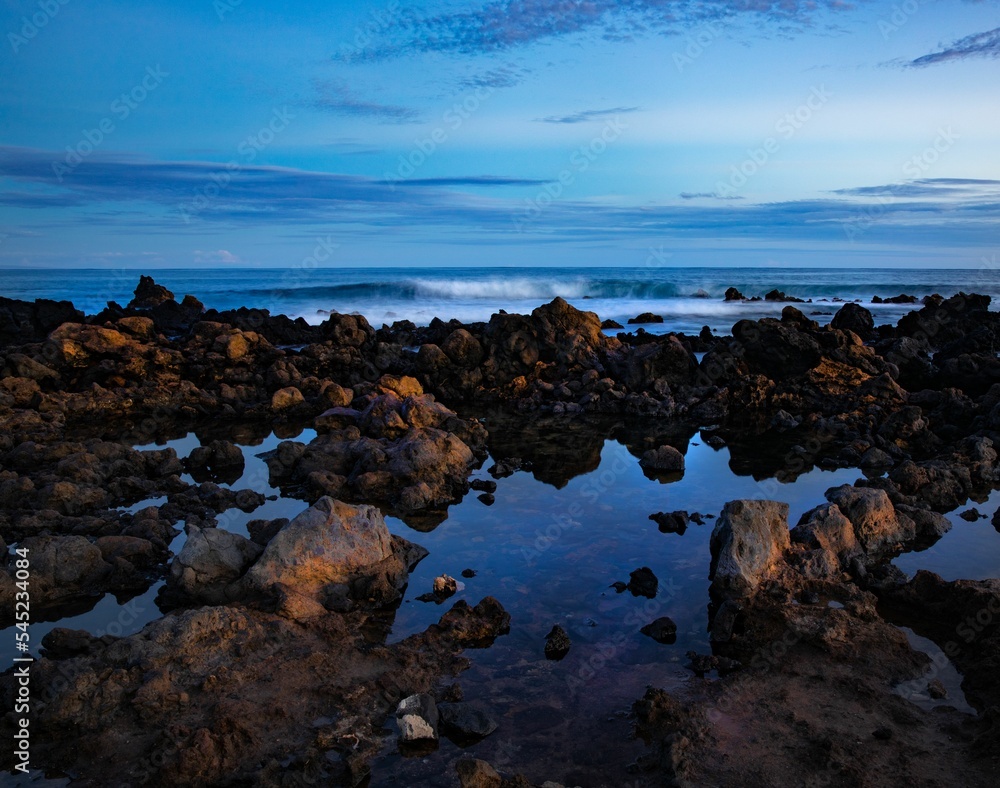 Rocky shore with the ocean and the horizon in the background under a blue sky