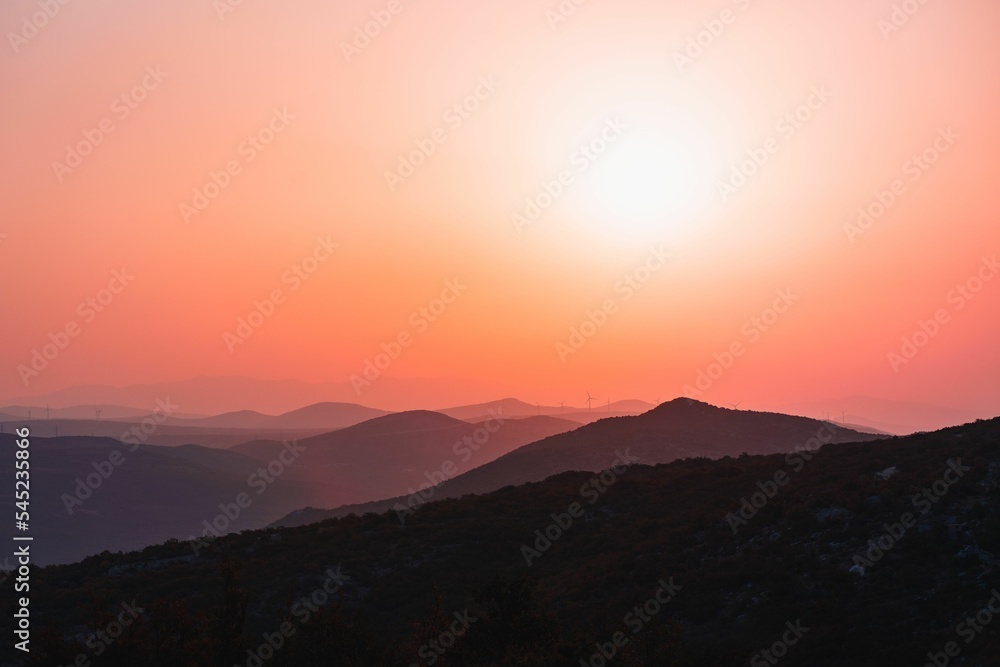 Scenic shot of mountain silhouettes of Mali Kozjak under a reddish sky in Dalmatia, Croatia
