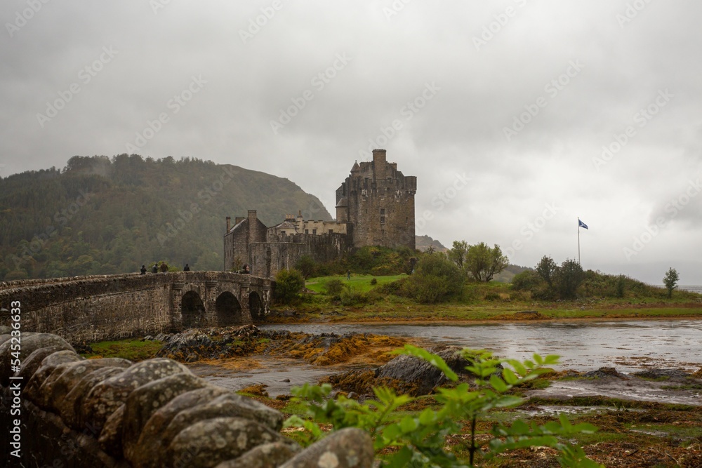 Beautiful shot of Eilean Donan Castle against a lake on a foggy day in UK