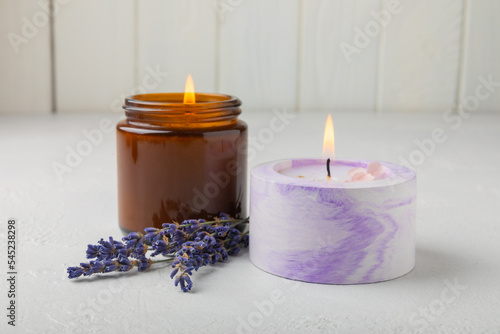 Aromatherapy concept  candle with lavender flowers.Soy candles with lavender scent. Candles on a white texture background. Place for text. Place for copying. Spa candles with a pleasant aroma.