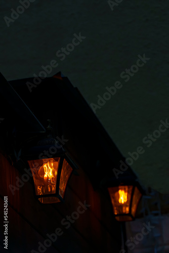 Vintage lanterns on a wooden wall on a dark evening