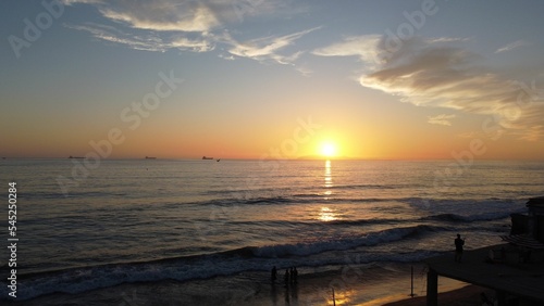 Scenic view of the sunset over a calm sea with tourists at the beach