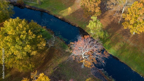 Fototapeta Naklejka Na Ścianę i Meble -  Aerial view over a lake in empty neighborhood park during the autumn season
