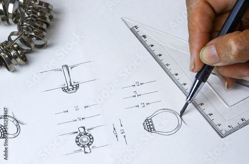 Jewelry design drawing On paper, draw a detailed diamond ring jewelry sketch on the top and side of the actual size of the jewelry. along with drawing tools and creative metal rings Design Studio. 