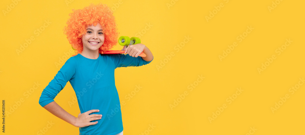 Fototapeta premium happy teen girl in fancy clown wig hold penny board, childhood. Funny teenager child on party, poster banner header with copy space.