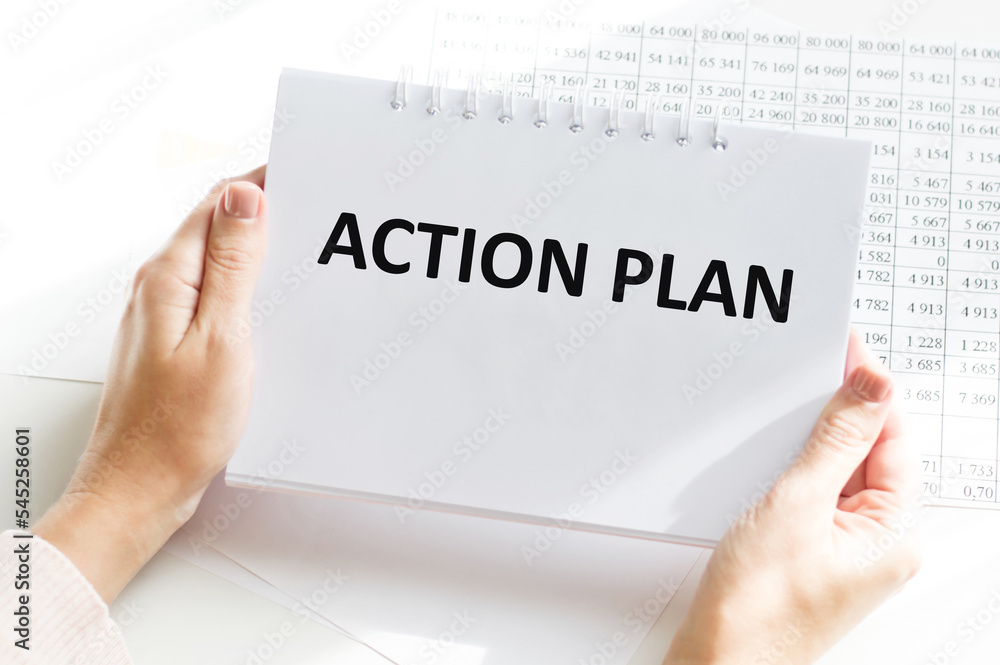 A male hand holds a notepad on a spring with the written ACTION PLANNING text. Office space. Business concept. A male hand holds a notepad on a spring with the written ACTION PLANNING text. Office space. Business concept.