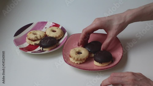 Female hands moving cookies from one plate to another