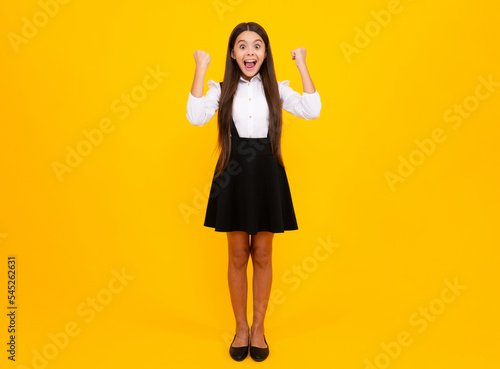 Amazed teen girl. Excited expression, cheerful and glad. Portrait of teenage girl child doing winner gesture. Kid rejoicing, yes victory champion gesture, fist pump.
