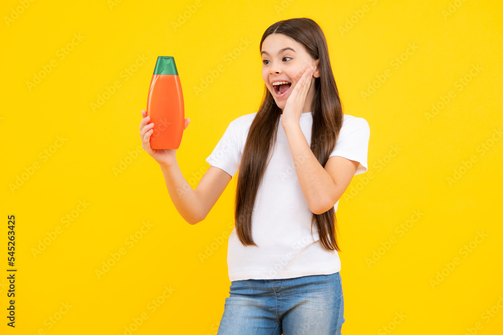 Child with shampoo conditioner. Daily cosmetic care. Teenager hold bottle of hair and skin care. Beauty health and cosmetics. Excited teenager, glad amazed and overjoyed emotions. Child with shampoo conditioner. Daily cosmetic care. Teenager hold bottle of hair and skin care. Beauty health and cosmetics. Excited teenager, glad amazed and overjoyed emotions.