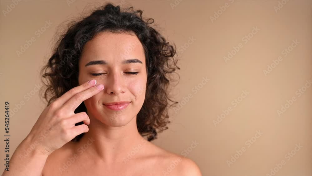 A young caucasian smiling woman is making a face mask, looking into the camera. Slow motion A young caucasian smiling woman is making a face mask, looking into the camera. Slow motion