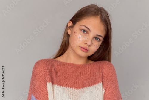 beautiful teen girl with shiny freckles portrait on grey background