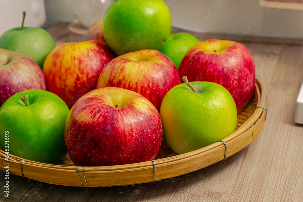 red and green apples isolated in wicker basket with wooden background red and green apples isolated in wicker basket with wooden background