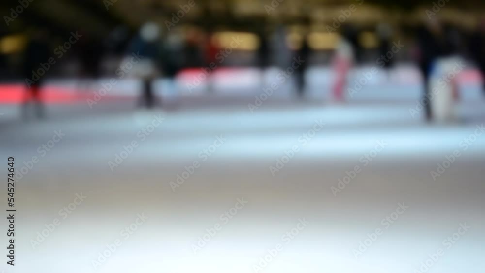 Blurred abstract background. Many people skating on an open-air ice rink on winter night. New Year Christmas holidays celebrate. Blurry colorful holidays backdrop Blurred abstract background. Many people skating on an open-air ice rink on winter night. New Year Christmas holidays celebrate. Blurry colorful holidays backdrop