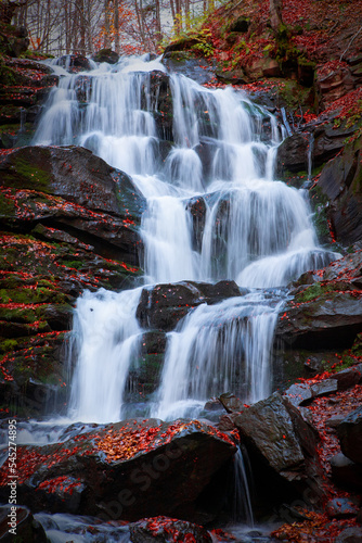 A waterfall in a beech autumn forest.