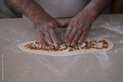 chef hand cookind pide on kitchen table photo