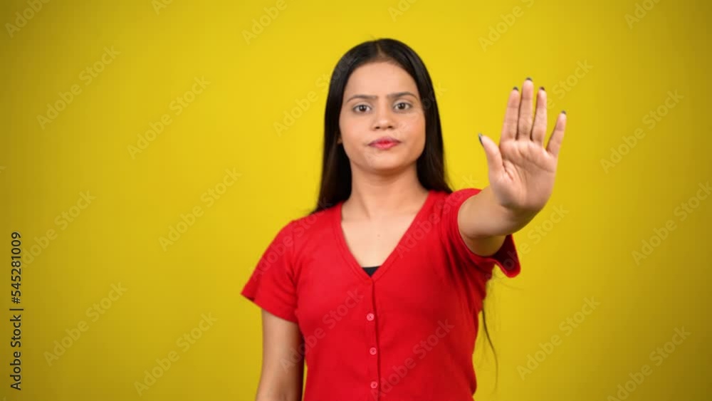 Portrait of a Asian beautiful young woman unhappy or confident standing say no, studio shot isolated yellow background, Indian female pose saying reject gesture with copy space Portrait of a Asian beautiful young woman unhappy or confident standing say no, studio shot isolated yellow background, Indian female pose saying reject gesture with copy space