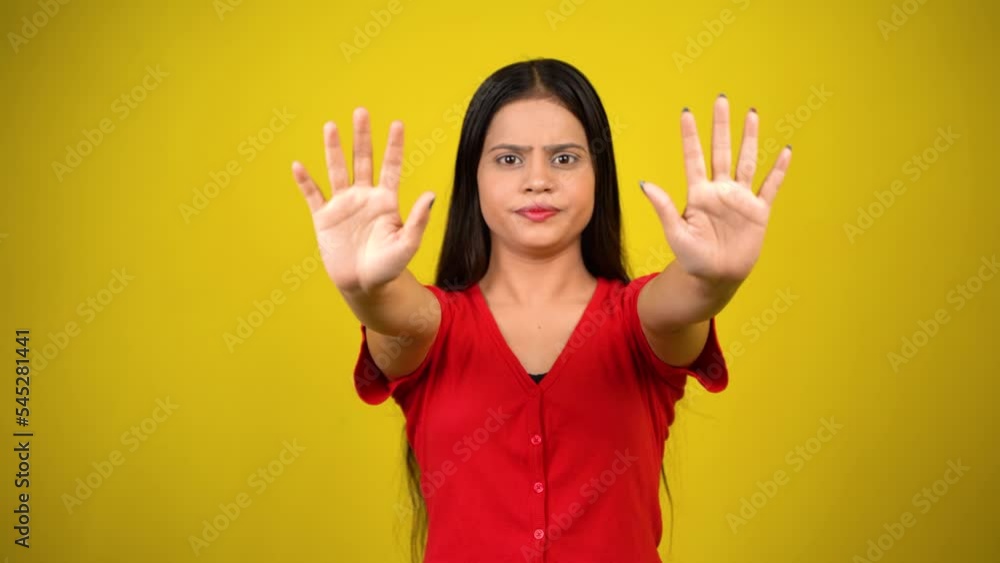 Portrait of a Asian beautiful young woman unhappy or confident standing say no, studio shot isolated yellow background, Indian female pose saying reject gesture with copy space Portrait of a Asian beautiful young woman unhappy or confident standing say no, studio shot isolated yellow background, Indian female pose saying reject gesture with copy space