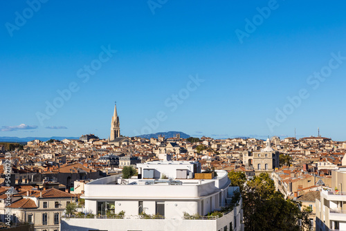 Vue sur le centre historique de Montpellier avec le Pic Saint-Loup et le clocher de l'Eglise Sainte-Anne depuis les toits du quartier contemporain du Nouveau Saint-Roch